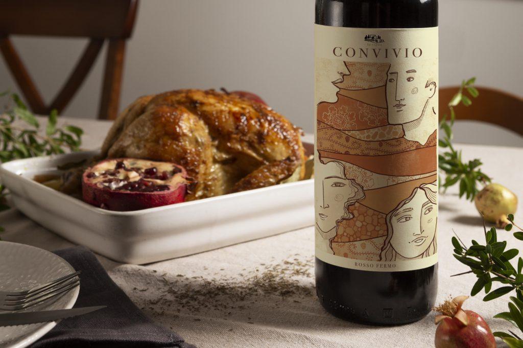 illustrated red wine label featuring faces and ancient motifs inspired to ancient mediterranean population